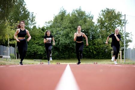 Auf der Aschenbahn sprinten Mädchen um die Wette.