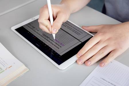 Schülerin schreibt auf Tablet